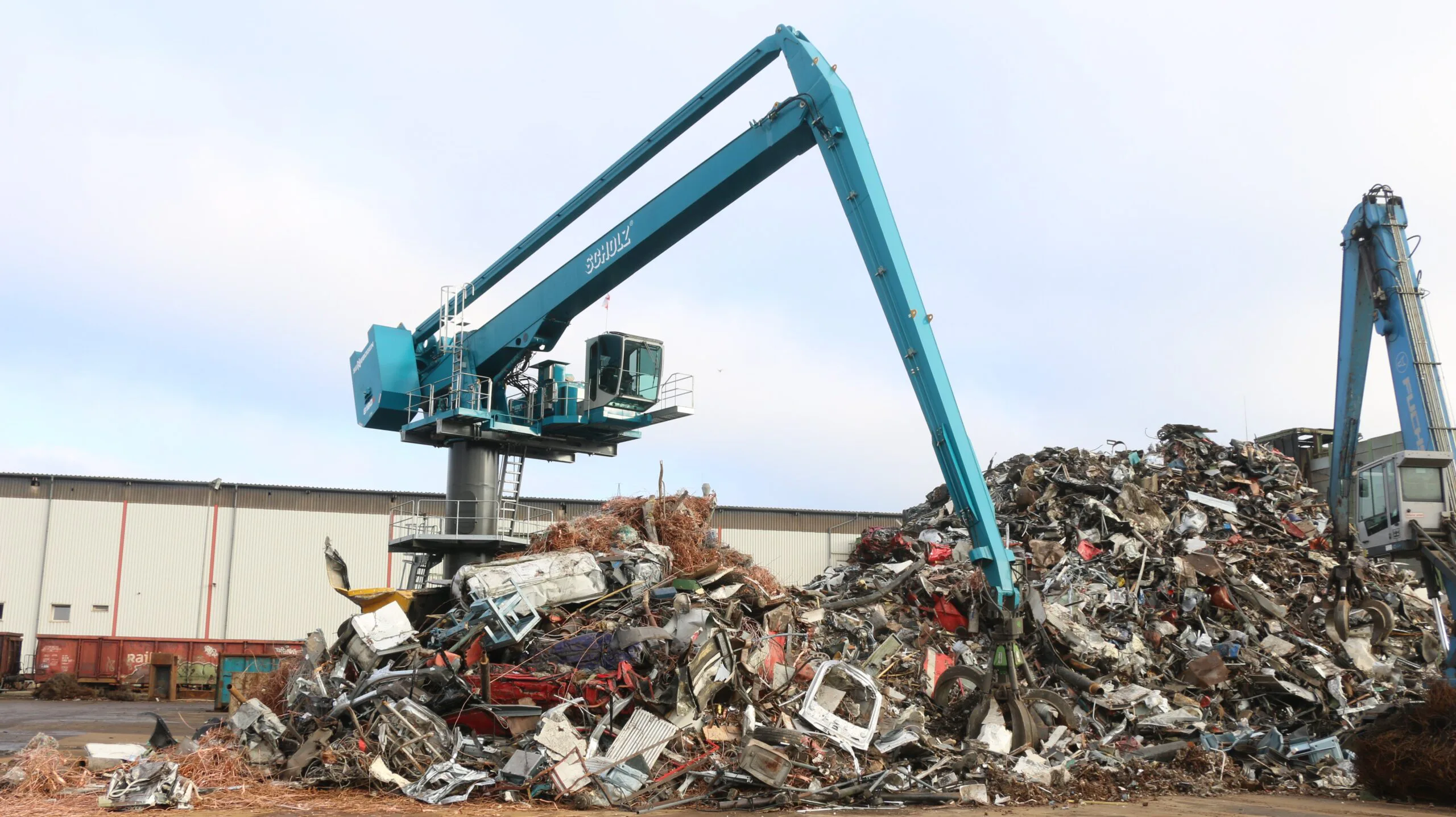 Zentral positioniert beschickt der Sennebogen 8130 EQ den 3.000 PS Shredder bei Scholz Recycling am Standort Espenhain. Dank Elektromotor und Balance Konzept arbeitet die Maschine leise und besonders energieeffizient bei einer Reichweite von 27 m.