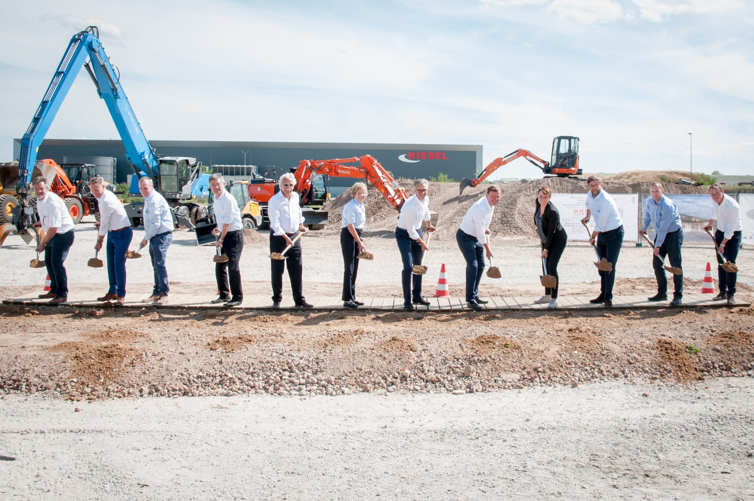 Spatenstich für die Kiesel Welt – die Beteiligten von links nach rechts: Thomas Raschel (Bürgermeister, Stockstadt), Walter Astheimer (Erster Kreisbeigeordneter, Groß-Gerau), Kieran Hegarty (Präsident, Terex Materials Processing, Terex Corp.), Kotaro Hirano (Präsident, Hitachi Construction Machinery); Helmut Kiesel (Firmengründer, Kiesel GmbH), Christa Kiesel (Firmengründerin, Kiesel GmbH), Jochen Kiesel (Gesellschafter – Kiesel GmbH), Toni Kiesel (geschäftsführender Gesellschafter – Kiesel GmbH), Kathrin Kiesel (Projektleiterin Kiesel Welt, Kiesel GmbH), Hans Jörg Reisch (Geschäftsführer, Georg Reisch GmbH & Co. KG), Andreas Heinrich (Geschäftsführer Bell Equipment Deutschland GmbH), Björn Hickmann (Projektleiter Kiesel Welt, Kiesel GmbH).
