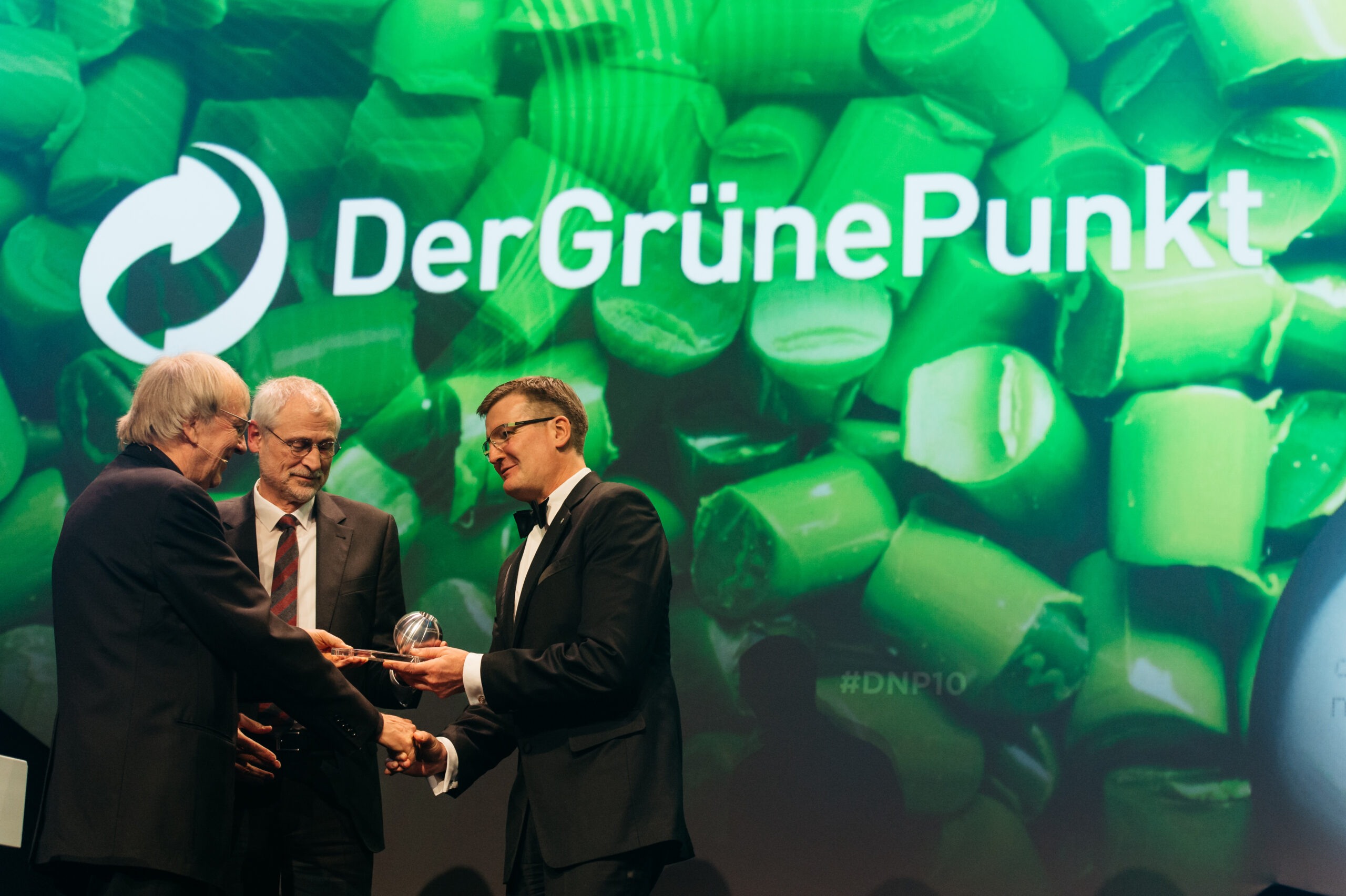 Jakob von Uexküll, Gründer des World Future Council und des Right Livelihood Award, und Hans Peters, Vorstandsvorsitzender des Instituts Bauen und Umwelt, überreichen den Deutschen Nachhaltigkeitspreis an Michael Wiener, CEO des Grünen Punkts (v. l.). (Bild: Dariusz Misztal/DNP)