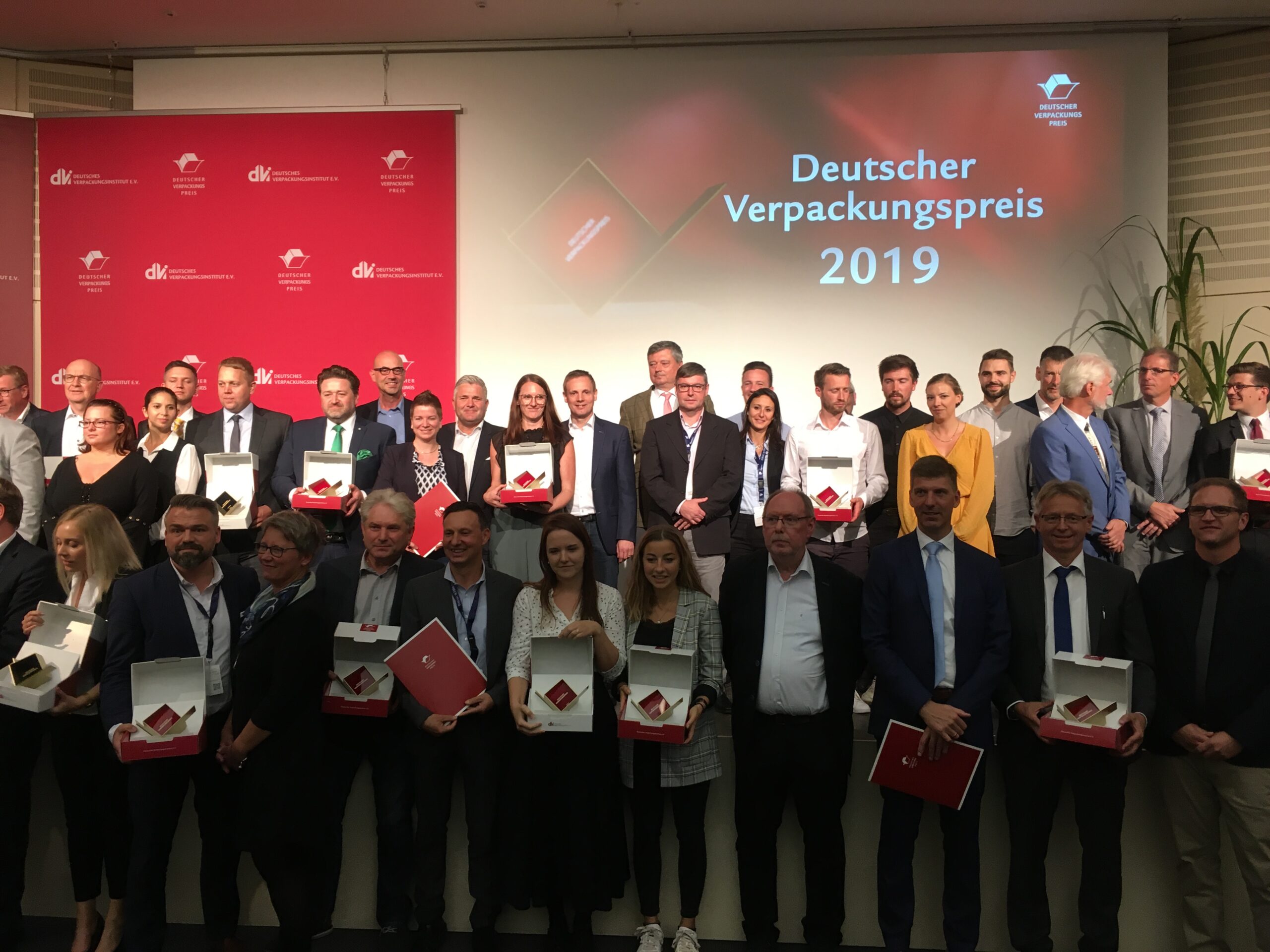 Im Kreis der strahlenden Gewinner auch Thorsten Weber vom Grünen Punkt (oberste Reihe, mit grüner Krawatte) mit dem Deutschen Verpackungspreis 2019. Bild: Der Grüne Punkt