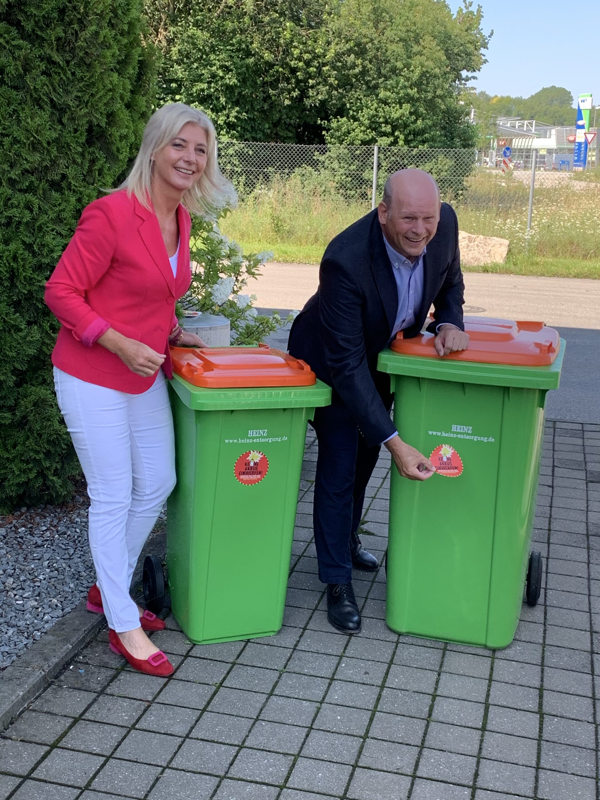 Die ehemalige bayerische Umweltministerin Ulrike Scharf und VBS-Präsident Heinz Otto bekleben die ersten Tonnen.