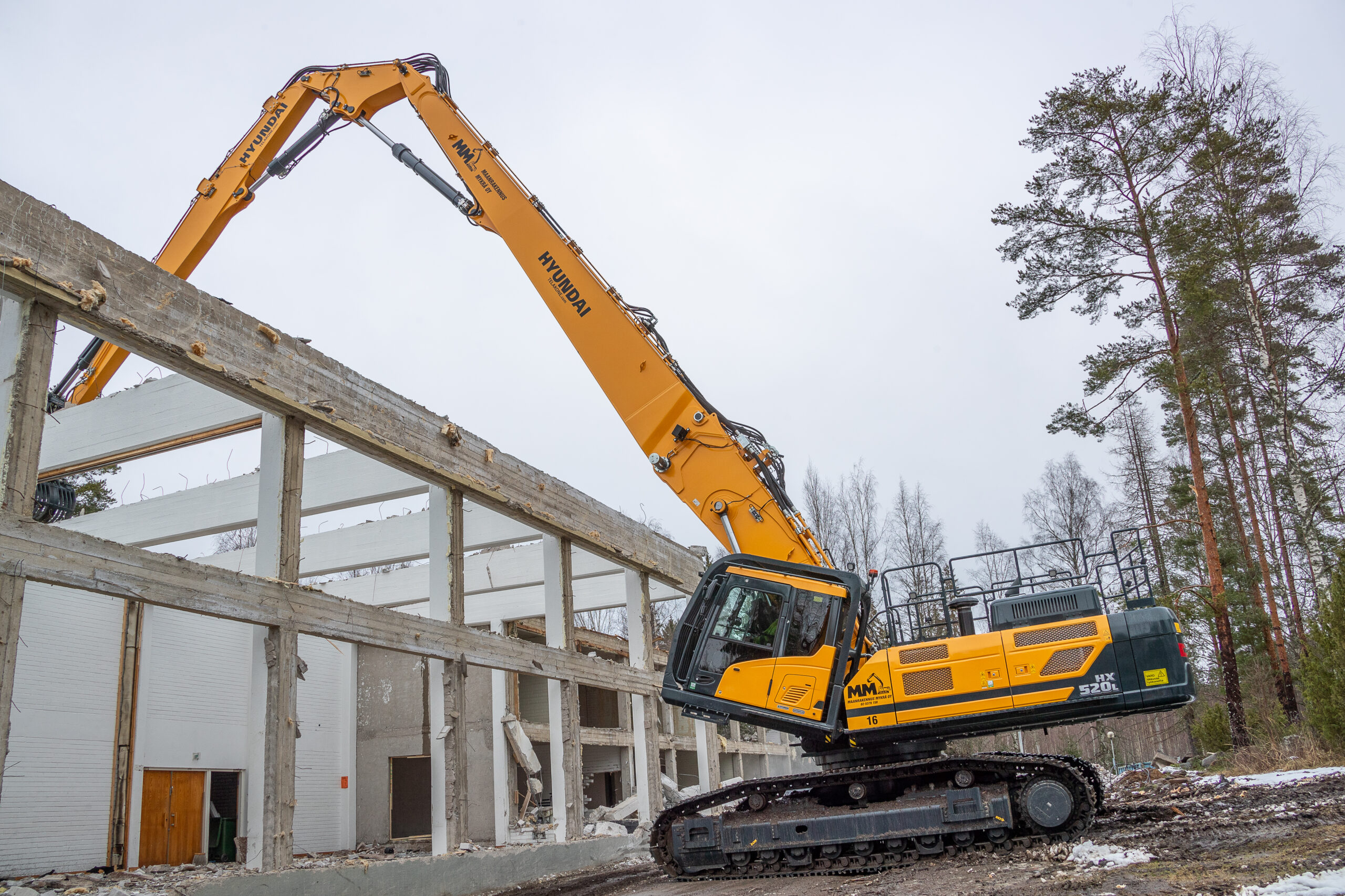 Typischer Einsatz mit dem 28 m langen dreiteiligen Ausleger – Arbeiten über eine Gebäudekante hinweg. Weitere Sonderausstattung ist die kippbare klimatisierte Kabine, damit der Bediener auch bei ausgestreckter Arbeitsausrüstung bequem arbeiten kann. Bild: Hyundai