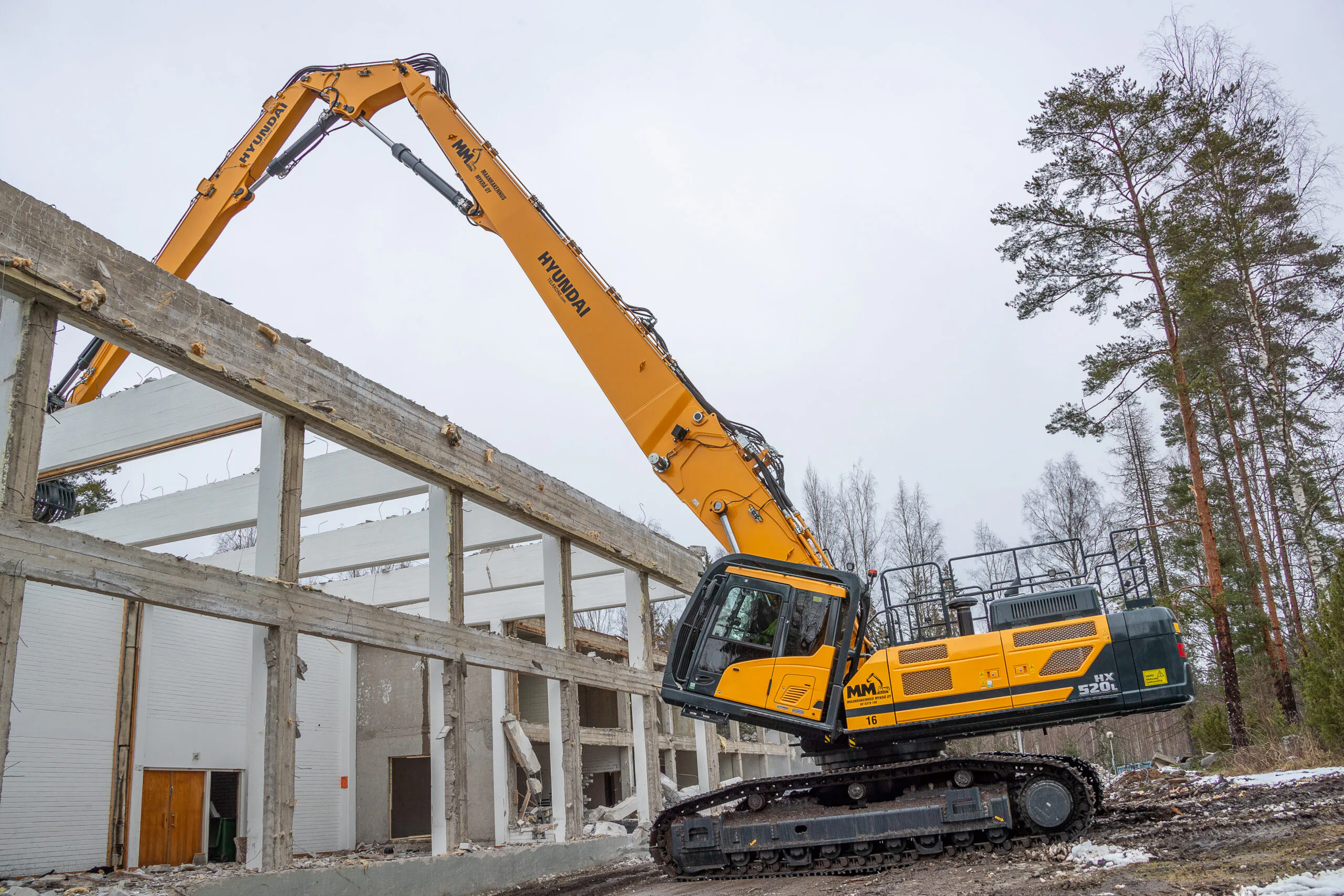 Typischer Einsatz mit dem 28 m langen dreiteiligen Ausleger – Arbeiten über eine Gebäudekante hinweg. Weitere Sonderausstattung ist die kippbare klimatisierte Kabine, damit der Bediener auch bei ausgestreckter Arbeitsausrüstung bequem arbeiten kann. Bild: Hyundai