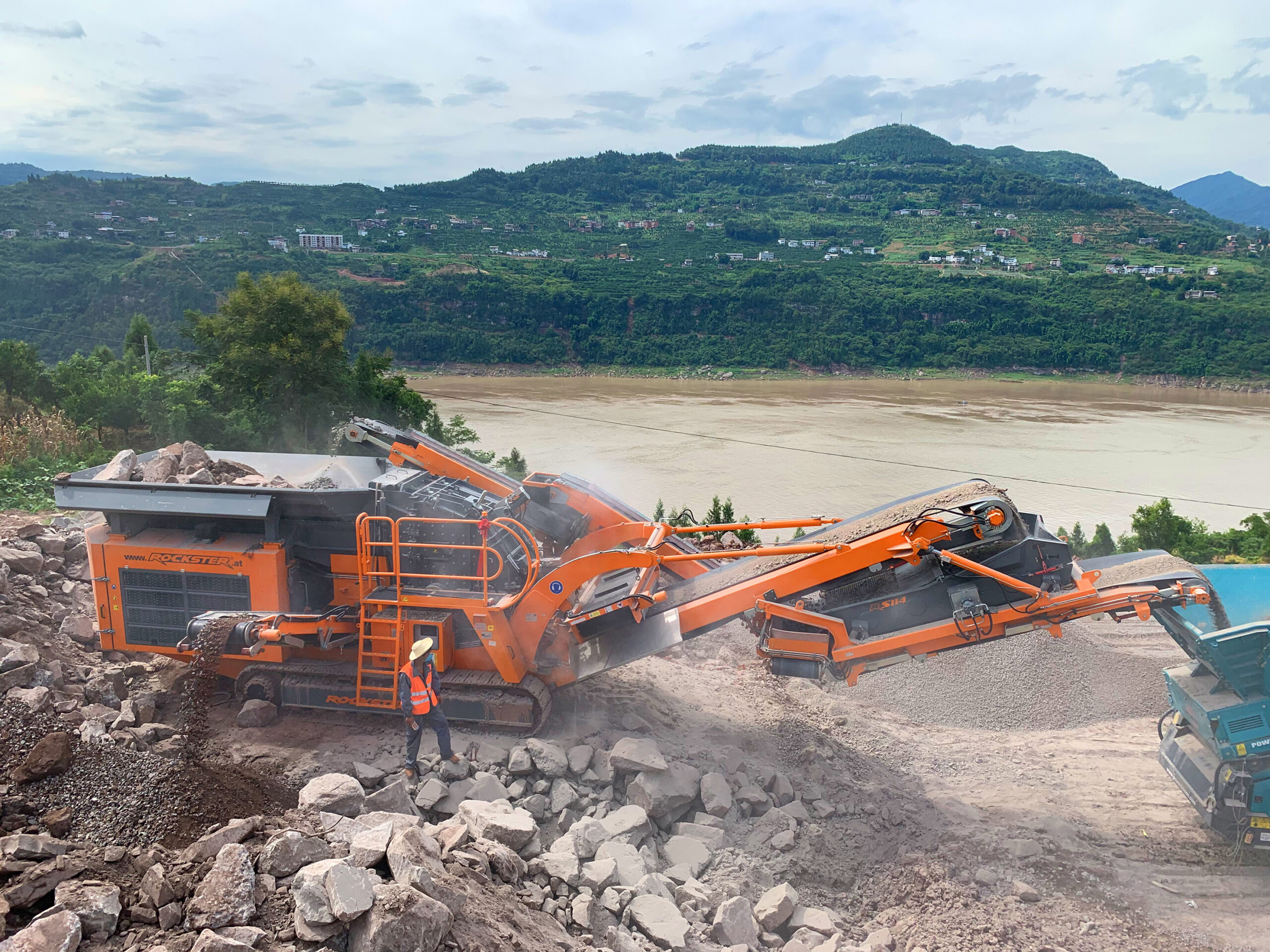 Rockster R1100DS in China: Aufgabematerial Granit mit bis zu 1000mm Durchmesser. Feines, erdiges Material wird durch die Vorabsiebung und das Seitenaustrageband entfernt, noch bevor es in die Brechkammer gelangt. Bild: Rockster