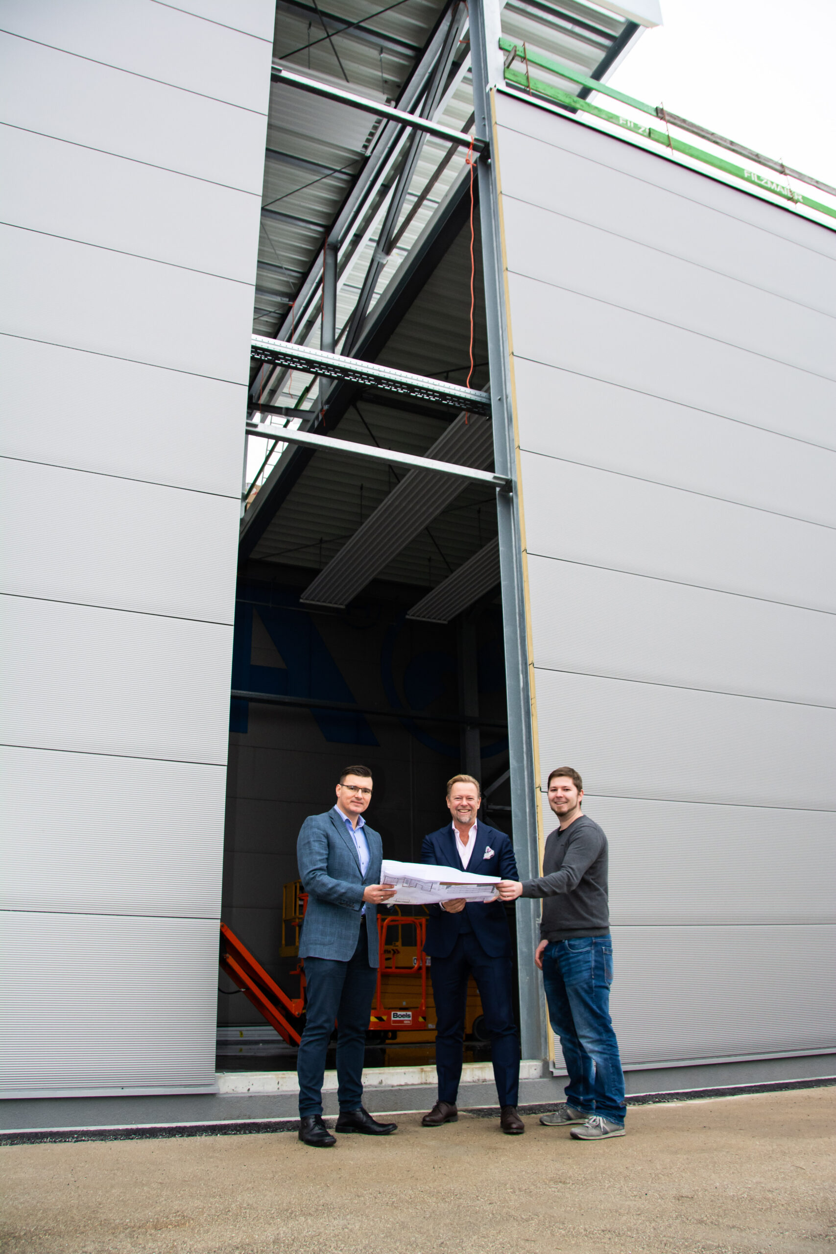 Michael Heitzinger (Managing Director, Erema), Christoph Wöss (Business Development Manager in der EREMA Group GmbH) und Patrick Rachinger (Product Group Manager, Erema) auf der Baustelle für das neue Kundenzentrum, in dem eine Vacunite-Anlage für Material-Testläufe installiert wird. Bild: Erema