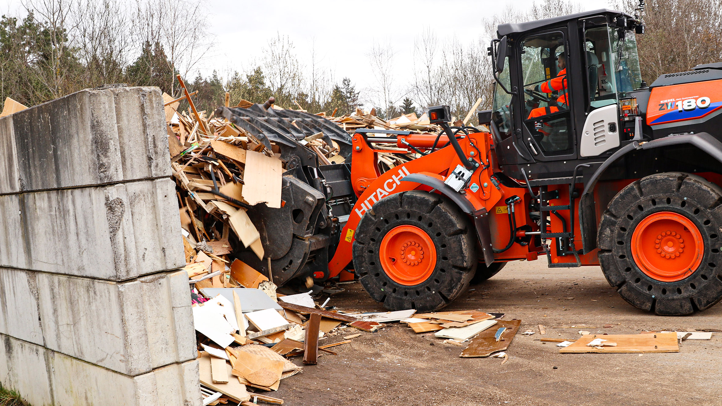 Der Hitachi ZW80 füllt seine Greifschaufel mit Altholz. Bild: Kiesel