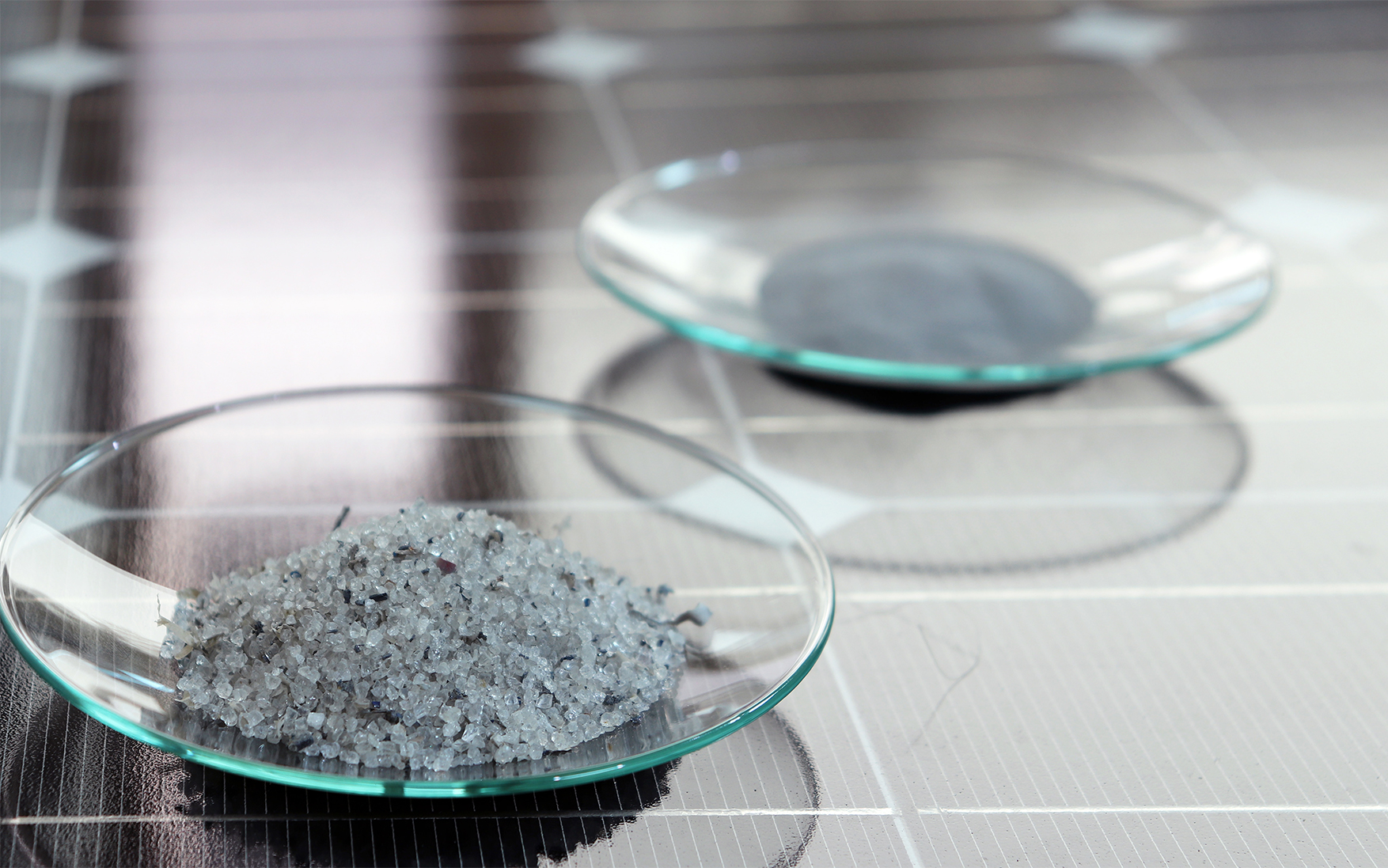 Materialfraktionen nach dem Recycling eines Photovoltaikmoduls: vorne Glas, hinten Halbleiterpulver. Bild: Fraunhofer IWKS