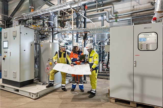 links und rechts: Johannes Neidel, Hillary Onyebuchi Onyishi (beide Fraunhofer UMSICHT), Mitte: Natividad Jordan Escalona (RWE) an der Anlage in Niederaußem. Copyright: RWE