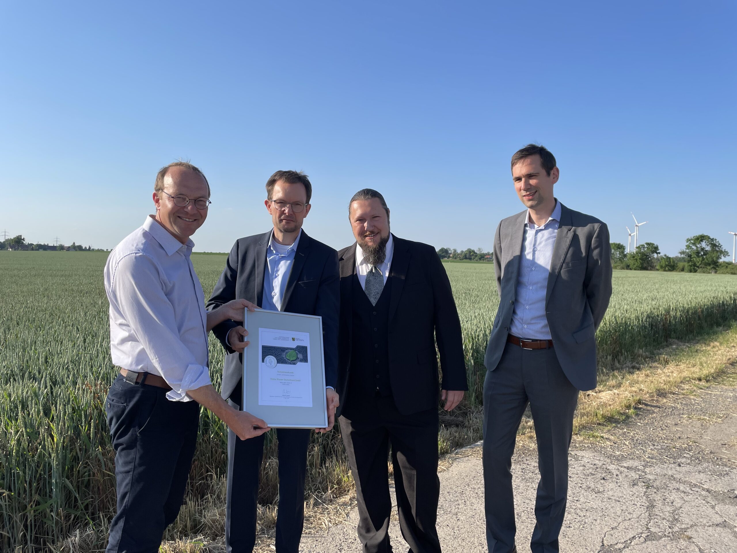 Ein Lob für den Umwelt- und Klimaschutz: Staatsminister Wolfram Günther (links) übergab in Raitzen dem Veolia-Team mit Geschäftsführer Thomas Kühn, Michael Kansy und Dr. Matthias Staub (v.l.n.r.) die 100. Urkunde der Umwelt- und Klimaallianz Sachsen. Copyright: Veolia