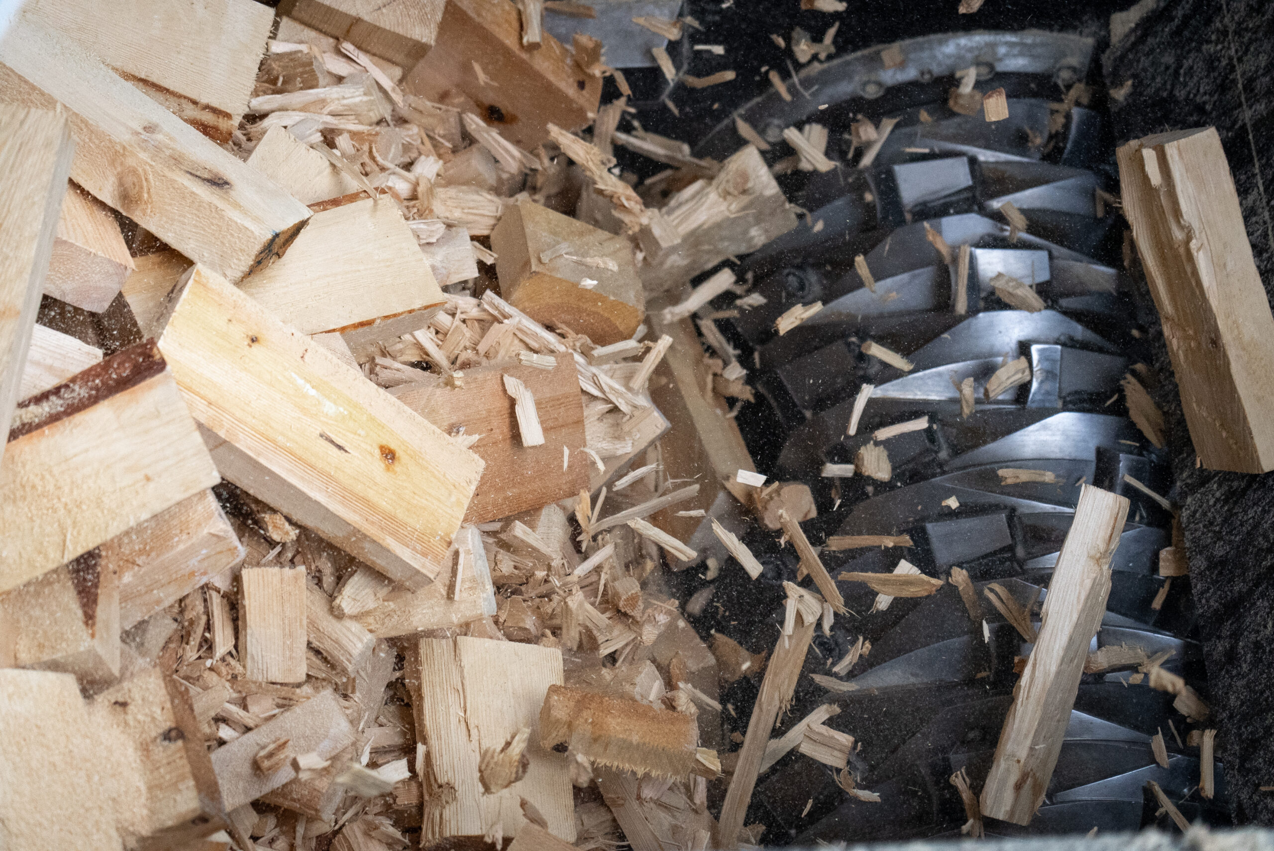 Copyright: Die Holzblöcke und -reste werden im Shredder zerkleinert.