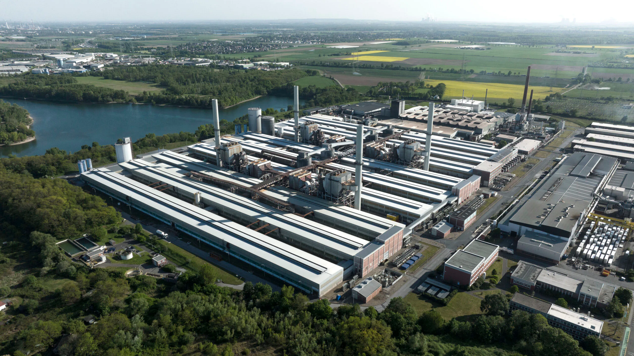 Rechts die Gießerei, in der der neue Ofen errichtet wird, vorne links die drei Hallen der heruntergefahreren Aluminiumhütte, die nun teilweise für neue Lagerflächen und die Beprobung genutzt werden sollen. Copyright: Speira
