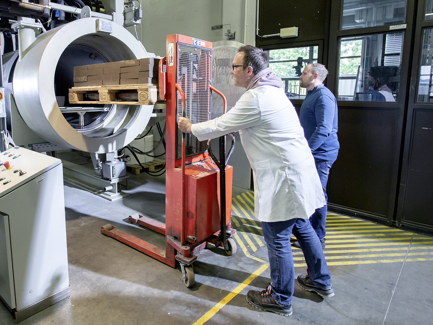 Michael Prokein (l.) und Jannick Armenat von Ruhrstoffbauwerke an der vorindustriellen Anlage zur Härtung von Baustoffen und CO₂-Speicherung. Copyright: Fraunhofer Umsicht