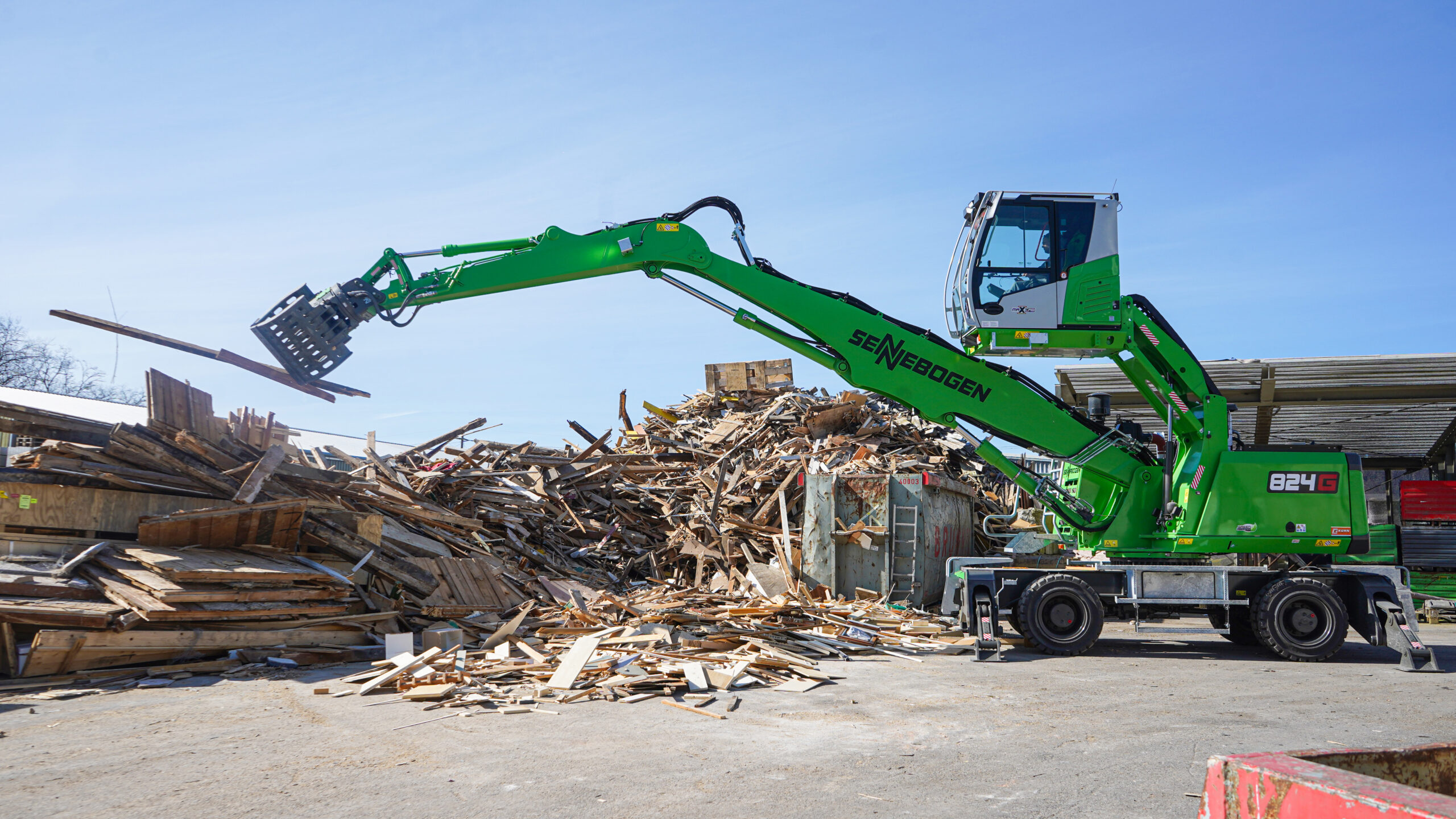Mit dem Sortiergreifer werden die Holzspaten an der dafür vorgesehenen Stelle abgelegt. Copyright: Awesome Earthmovers