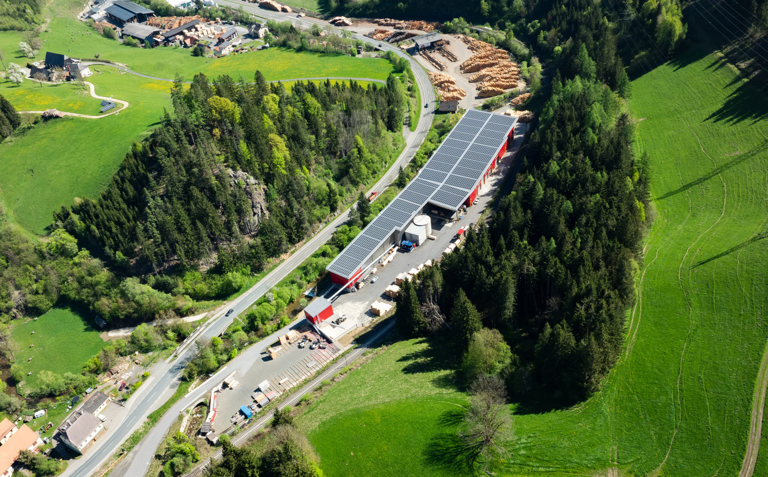 Die enge und schmale Bauweise des Sägewerks erfordert eine maßgeschneiderte Planung. Es erstreckt sich entlang eines Baches und wird auf der gegenüberliegenden Seite von Bahngleisen begrenzt. Copyright: Vecoplan AG