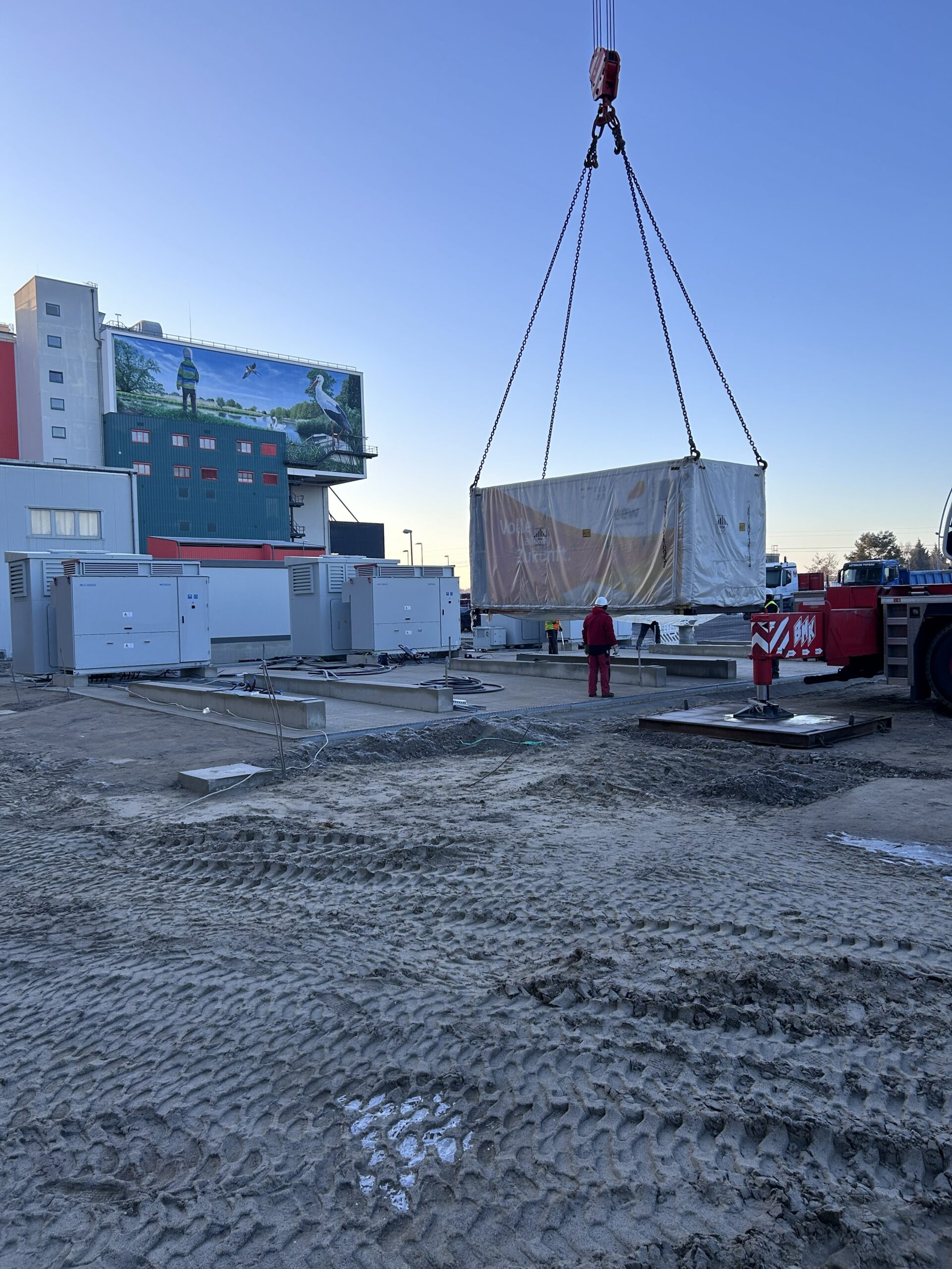 Der erste von insgesamt drei Batteriespeichercontainern hat seinen Bestimmungsort erreicht. Ein 250-Tonnen-Teleskopkran hob den 44 Tonnen schweren Container auf das Fundament.