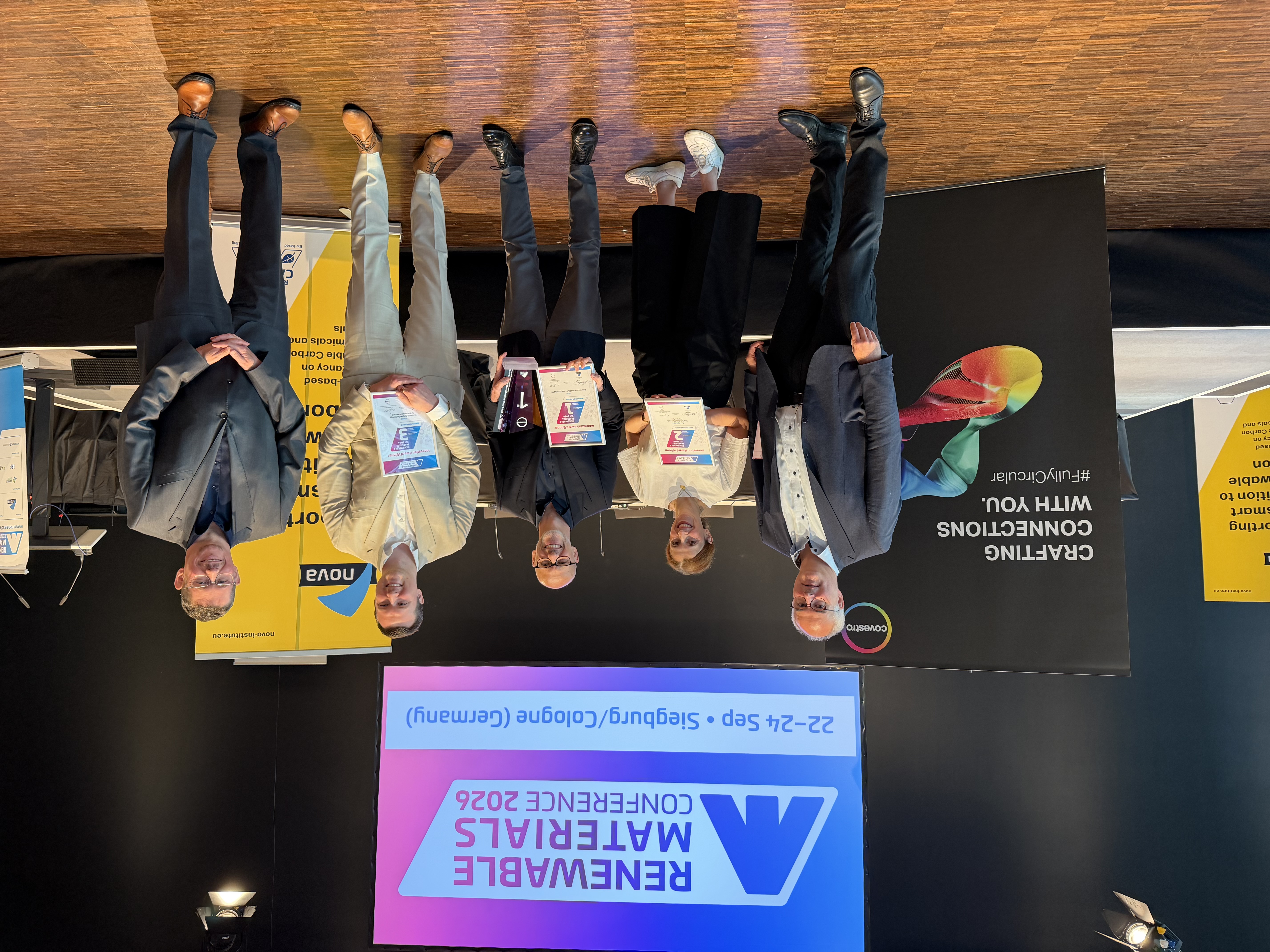 
Gewinner des Innovation Awards „Renewable Material of the Year 2026“. Links Dr. Christoph Gürtel (sponsor Covestro), rechts Dr. Lars Börger (ECO, organiser nova-institut). In der Mitte von links nach rechts: Nick Smith (commercial director) and Dr. Daniel Stewart (CEO), Viridi (UK) 
